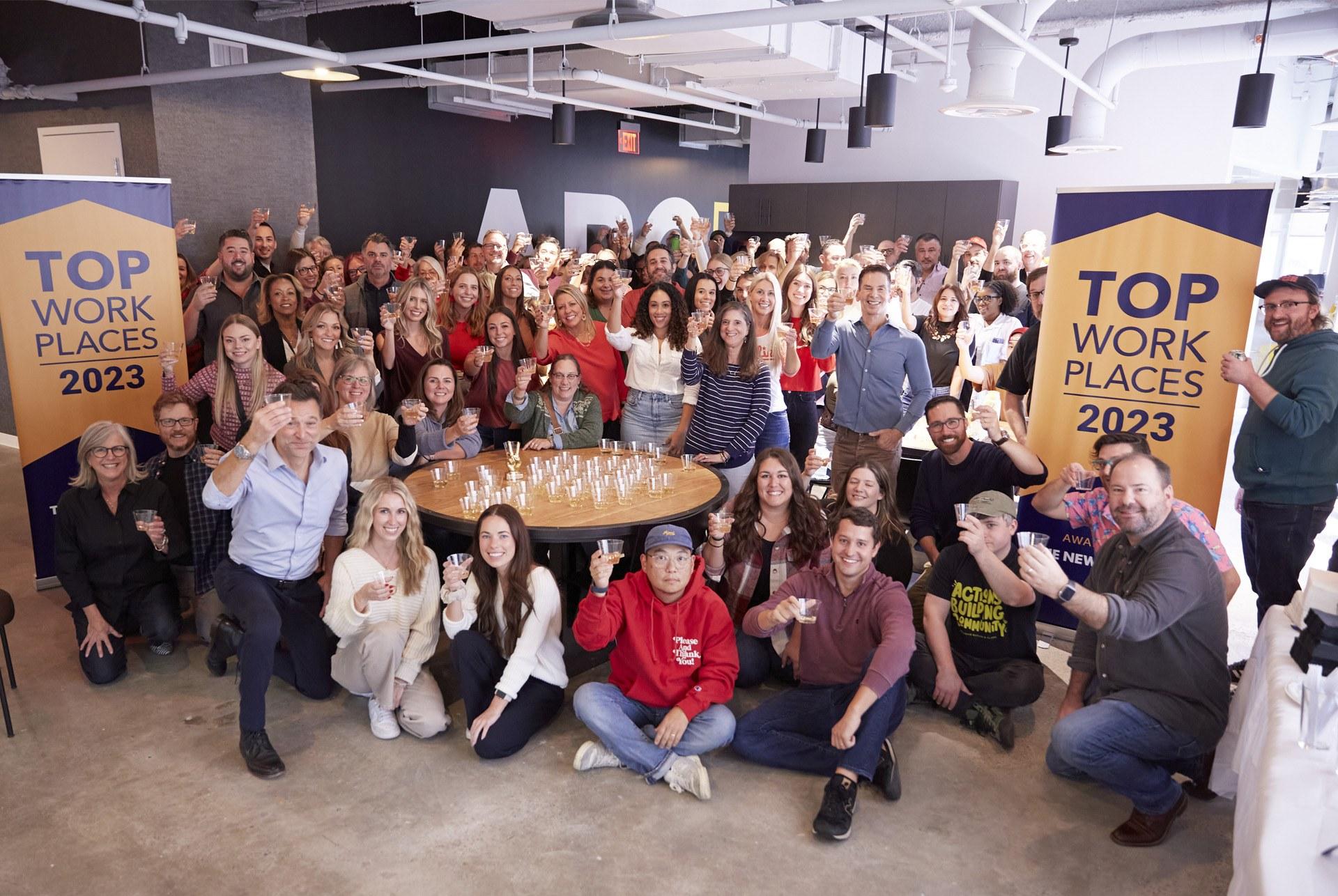 Team photo with Top Workplaces 2023 banners