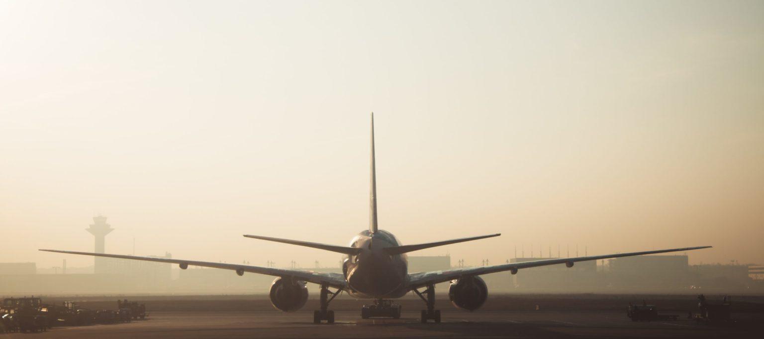 Airplane on a runway from behind.